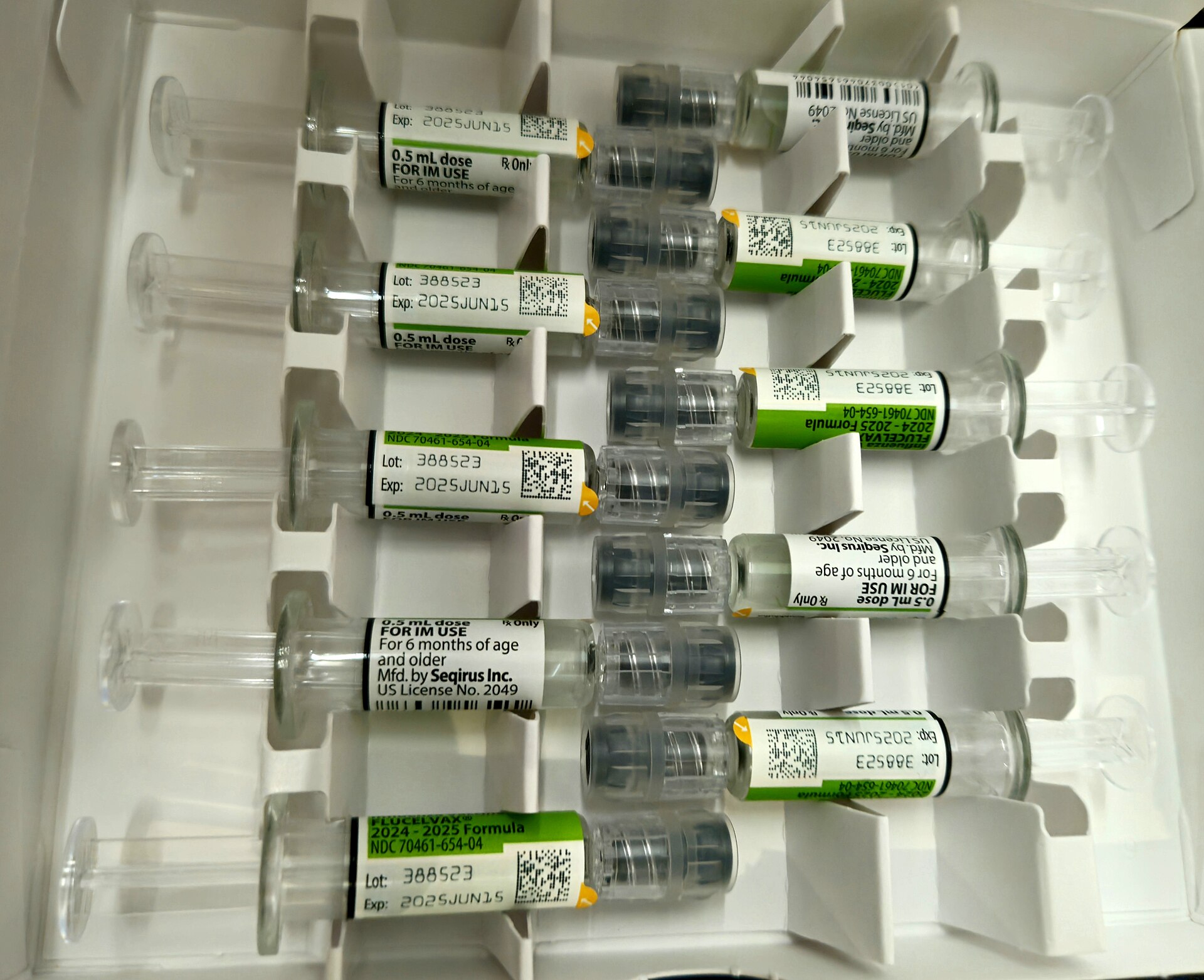 A tray of prepared single-dose vaccine syringes