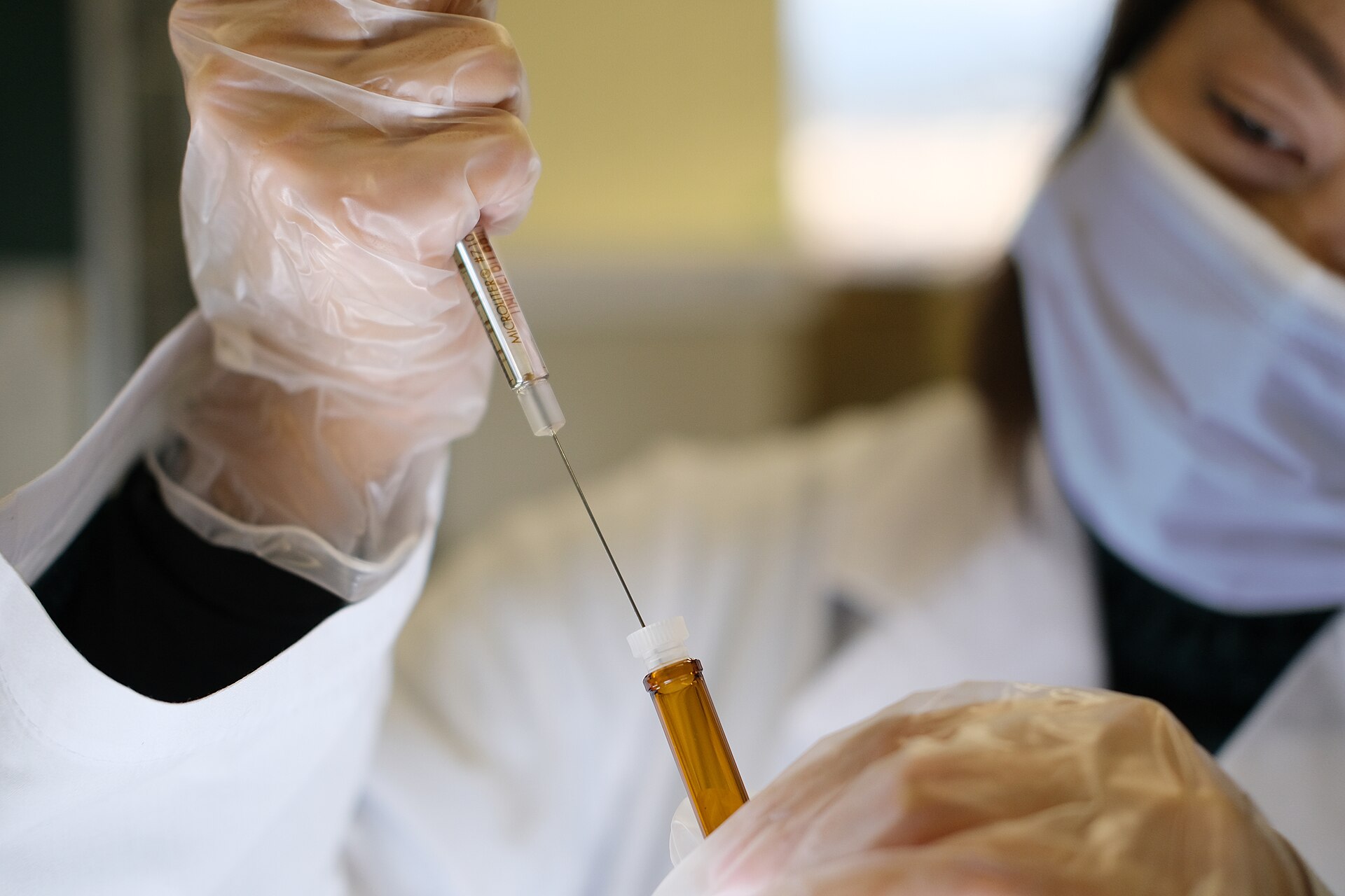 A healthcare professional drawing a vaccine dose from a vial into a syringe