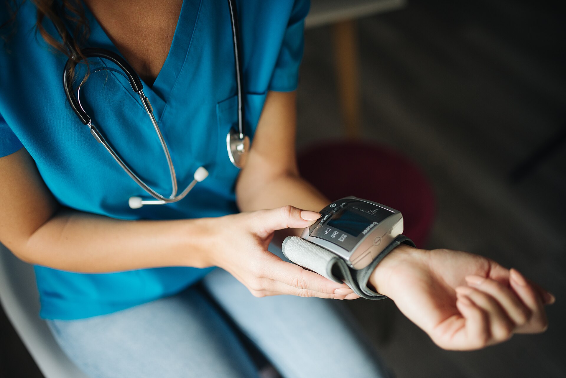 A clinician measuring blood pressure with a digital monitor