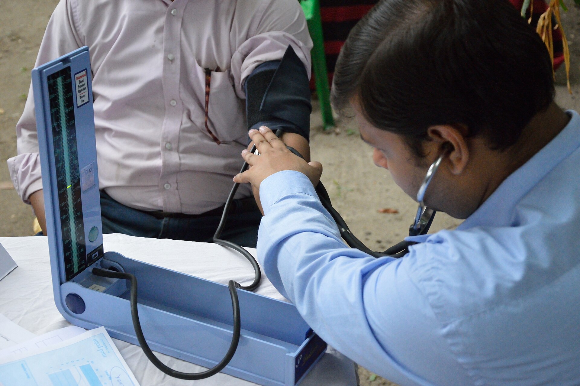 A blood pressure reading being taken with a cuff and stethoscope